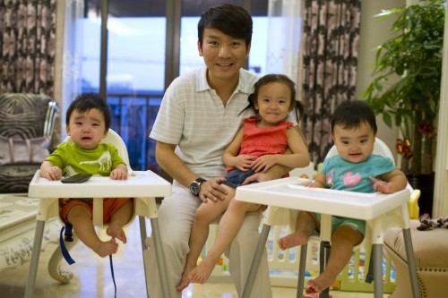 Tony Jiang poses with his three children at his house in Shanghai